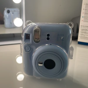 Instax Mini 12 - Fånga ögonblicken direkt med Instax Mini 12! Denna snygga, ljusblå kamera är perfekt för dig som vill skapa minnen med vänner och få ut foton direkt i handen. Enkel att använda och smidig att ta med på äventyr. Säljs med skyddande transparent fodral.