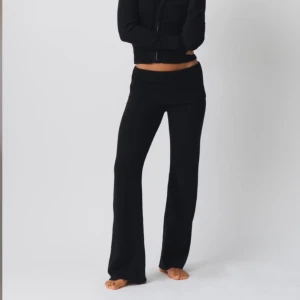 Svarta stickade byxor Gina Tricot S - Svarta stickade byxor från Gina Tricot i storlek S. Byxorna har bred ribbad midja, är låga i midjan och har en rak, lite vidare passform. Perfekta för en chill och trendig look. Mjukt och stretchigt material som känns skönt mot huden.