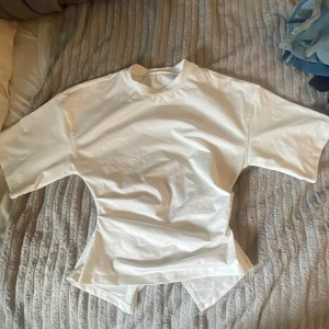 Vit tröja - Vit t-shirt från Shein i storlek XS. På baksidan är den lite öppen lite längre ner och den har lite längre ärmar än vanliga t-shirts.