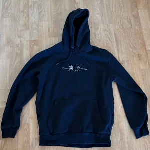 Svart hoodie LCW Casual Tokyo-print - Svart hoodie från LCW Casual i storlek M med japanskt Tokyo-tryck fram och bak. Klassisk känguruficka, snörning i huvan och mjukt material. 