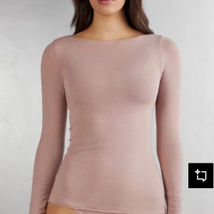 Ljusrosa långärmad topp i bomull - Supersnygg ljusrosa långärmad topp med tight passform och rund halsringning. Tillverkad i mjuk bomull som sitter skönt mot kroppen. Perfekt att styla med jeans eller kjol för en clean och enkel look.