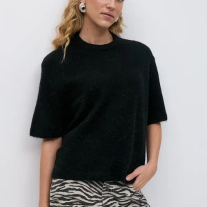 Svart stickad tröja från Gina tricot - En svart stickad tröja från Gina med kort ärm och rund hals. Tröjan har en loose passform och är gjord i ett mjukt, fluffigt material som känns lyxigt. Perfekt att styla med jeans eller kjol för en chill look.
