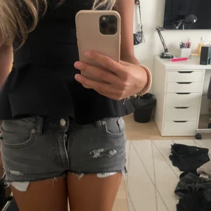 Grå  low waist jeansshorts  - Snygga grå jeansshorts med råa kanter och slitna detaljer framtill. Modellen är lågmidjad och har klassiska fem fickor. Perfekta för sommaren och ger en cool, avslappnad vibe. 
