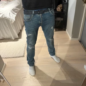 Blå jeans med slitningar - Snygga blå jeans med slitningar på knäna och låren | riktigt efterfrågade då dem är slutsålda för det mesta | storlek 34/32 | jag är 182cm | helt nya och inga defekter | det är en storlek större än vad jag brukar ha då dem är slimfit | tveka inte vid intresse eller funderingar 