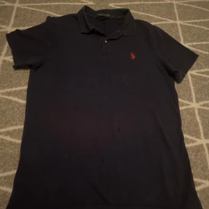 Mörk/marinblå piké T-shirt från U.S. Polo Assn - Mörk/marinblå piké T-shirt från U.S. Polo Assn  Aldrig använd av mig men fick begagnad Mycket bra skick i storlek M  Postar inom 24h  Kontakta om frågor eller funderingar