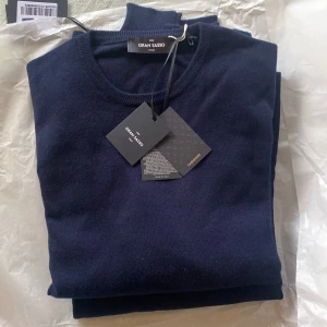 Gran Sasso 100% Kashmir tröja - Säljer en lyxig mörkblå kashmirtröja från Gran Sasso. Tröjan är tillverkad i 100% kashmir och har en klassisk rund halsringning. Perfekt för att hålla dig varm och stilren under kyligare dagar. Men även perfekt för vår och höst. Nypris ligger på 3999kr. Helt ny som från butik. Storlek 48=M/S