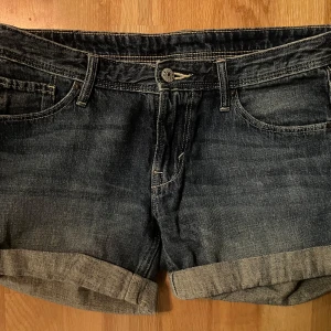Mörkblå jeansshorts - Säljer ett par mörkblå jeansshorts med uppvikta kanter. Köpta i en secondhand butik men säljer igen för att de inte passade mig. 