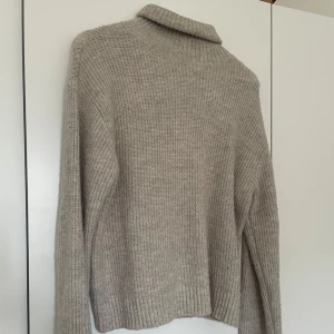 Beige stickad polotröja från H&M - Stickad polotröja från H&M. I nyskick.