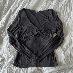 Mörkgrå långärmad topp - Mörkgrå topp med långa ärmar och v-ringning. Storlek L men passar S-L beroende på hur man vill att den ska sitta. 