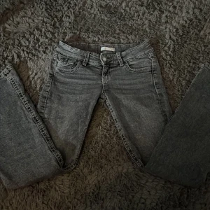 Grå jeans från Gina Tricot - Snygga grå jeans från Gina Tricot med dekorativa bakfickor. De har en klassisk femficksdesign och en knappgylf. Perfekta för en stilren look. Är lite rostiga på knapparna som ni ser på de sista bilderna, men inget man tänker på. Nypris 400 säljer för 150