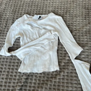 Vit ribbad långärmad topp - Säljer en stilren vit ribbad topp med långa ärmar. Perfekt för lager-på-lager eller som den är. Enkel och mångsidig i garderoben.