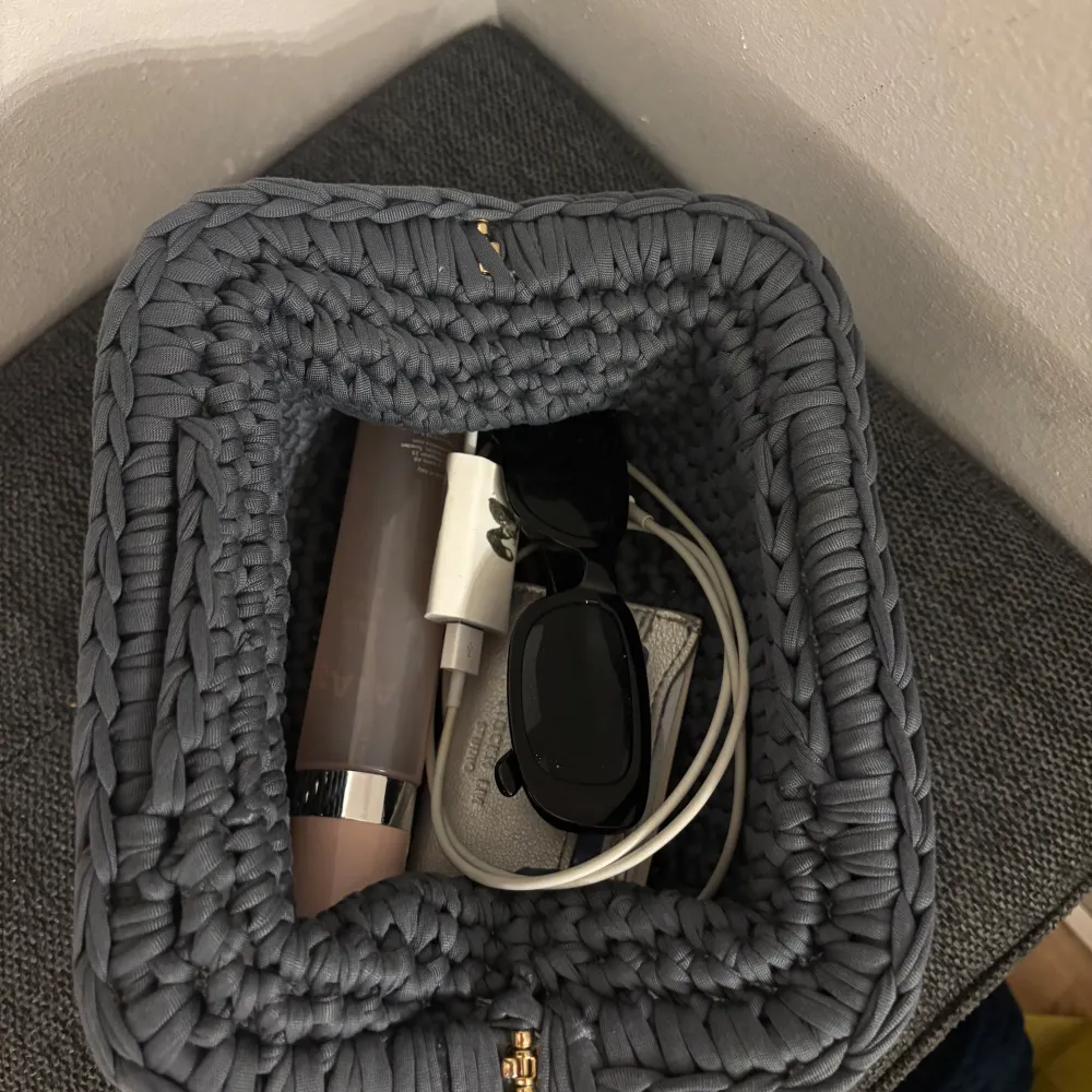 Säljer en grå handvirkad clutch / handväska. Väskan är i ett mjukt garn och är väldigt rymlig! Kan bäras i handen som en clutch eller bäras i handtaget.  Kan Även Göra Andra Färger / storlekar💕. Laukut & Käsilaukut.