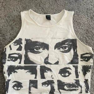 Vit linnetopp med ansiktsmönster - Säljer en cool vit linnetopp från shein med ett unikt ansiktsmönster i svart. 