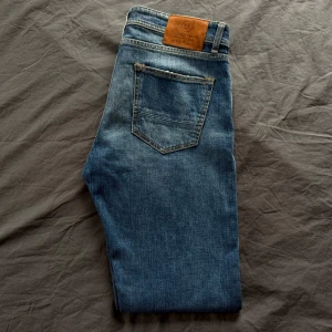 Blå jeans från Taylor Tweed - Snygga blå jeans från Taylor Tweed, tillverkade i Italien. De har en klassisk femficksdesign. Perfekta för en stilren look. Nypris runt 2500.