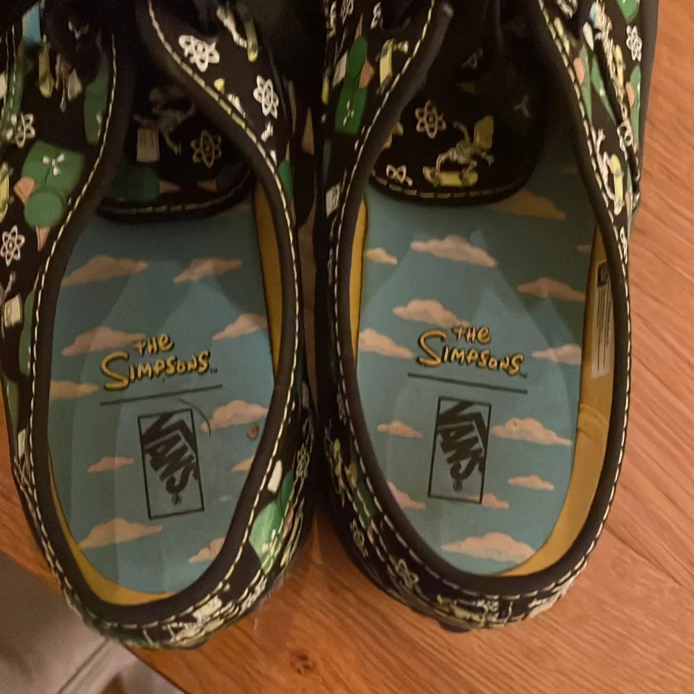 Unika Vans sneakers i samarbete med The Simpsons. Skorna har ett grönt och svart mönster med karaktärer från serien och svarta snören. Innersulan är dekorerad med The Simpsons-logotypen och ett himmelsmotiv. Perfekta för fans av serien! Använda en gång . Kengät.