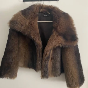 Brun pälsjacka från Vila - Säljer en lyxig brun pälsjacka från Vila. Jackan har en elegant design med en stor krage och är perfekt för att gå en lyxigare känsla . Den är långärmad och ger en glamorös look.