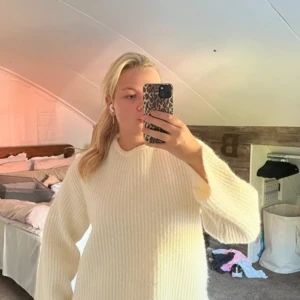 Vit stickad tröja med öppen rygg och rosett från Gina Tricot - Säljer en vit stickad tröja från Gina Tricot med lång ärm. Tröjan har en snygg öppen rygg med en rosett som detalj. Perfekt för dig som vill ha något både mysigt och trendigt. Sitter normalt och är supermjuk.