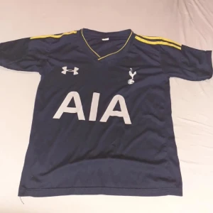 Tottenham fotbollströja - Retro Tottenham Hotspur matchtröja – ett måste för alla Spurs-fans och samlare! Ikonisk design med klassiska klubbmärket och sponsortryck. Perfekt för dig som älskar vintage fotbollströjor eller vill bära din stolthet med stil. Inga hål eller större slitage – ett riktigt samlarfynd!