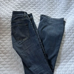  Bootcut jeans från Nelly - Säljer ett par blå bootcut jeans från Nelly med dubbla knappar i midjan och framfickor med lock. Jeansen har markerade sömmar längs benen. De är super fina men även bekväma. Ca använda 5 gånger. Skriv för fler frågor eller intresse. 🫶🏻