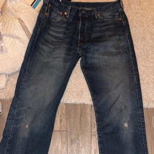 Mörkblå Levis 501 jeans - Klassiska mörkblå Levis 501 jeans med raka ben. Perfekt skick och perfekt för alla väder. Ordinarie pris ca 1200. Dessa är sällan använda och i perfekt skick, passa på o unna dig genom att klicka hem dom! Storlek 31x32