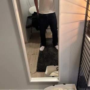 Mörkblå Levis 501 jeans - Säljer ett par klassiska mörkblå Levis 501 jeans med raka ben och normal passform. Byxorna har fem fickor, synliga sömmar och Levis ikoniska läderpatch bak i midjan. Perfekta för en stilren och tidlös look.