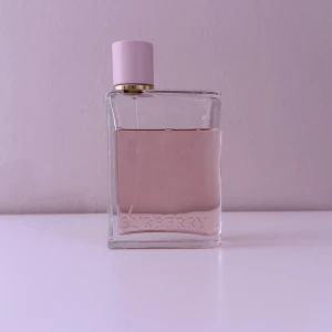 Burberry Her Eau de Parfum - Burberry Her Eau de Parfum i en elegant glasflaska med ljusrosa lock och guldiga detaljer. Parfymen rymmer 100 ml (se bilder för hur mycket som är kvar). Perfekt för dig som gillar gourmand, fruktiga och söta dofter.