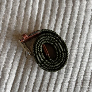 Flätat grönt bälte med bruna skinn-detaljer - Snyggt flätat bälte i mörkgrön färg med bruna skinn-detaljer vid spännet och metallspänne. Perfekt accessoar för att lyfta din outfit med en stilren touch. Kontakta mig vid frågor🙋‍♂️