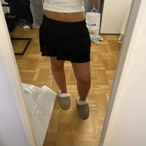 Svart kortkjol med volang från Gina Tricot - Säljer en svart kortkjol från Gina Tricot i storlek XS men passar s och m också. Kjolen har volangdetaljer och är aldrig använd 