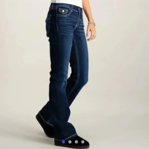 Mörkblå bootcut jeans med fickdetaljer - Snygga mörkblå jeans med bootcut passform och kontrastsömmar. Byxorna har klassiska fickor både fram och bak med lock och knappdetaljer bak. Perfekta för dig som gillar en tidlös jeansstil.