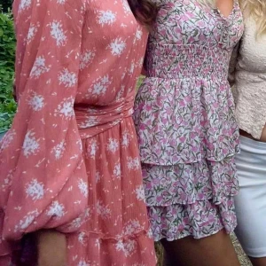 Blommig kortklänning från NA-KD - Säljer en superfin klänning från nakd💕snöret till knappen har gått sönder, men kan sys lätt eller använda säkerhetsnål som ej syns!!