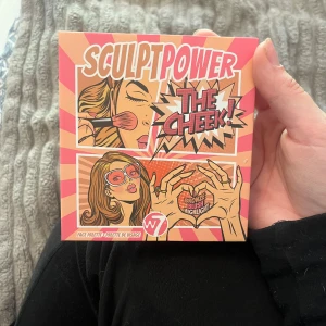 W7 Sculpt Power The Cheek! Face Palette - En ansiktspalett med fyra nyanser: bronzer (Honolulu), rouge (Rebel), highlighter (Shy) och blush (Cheeky). Paletten har en pop art-inspirerad design i rosa och orange toner. Perfekt för att skulptera och framhäva ansiktet. Aldrig använd men lite skadad på highlightern 