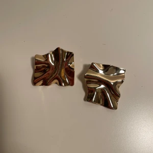 Guldiga vågiga örhängen - Jättefina guldfärgade örhängen i snygg design💫