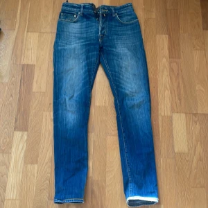 Blå jeansbyxor från Jacob Cohen - Säljer ett par klassiska blå jeansbyxor från jacob Cohen med normal passform och raka ben. Byxorna har fem fickor, dragkedja och knapp i midjan. Perfekta till vardags och lätta att matcha med olika stilar.