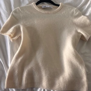 Beige stickad T-shirt  - Säljer en beige stickad T-shirt från Zara. Är verkligen superfin till alla väder. Är storlek M men passar mer S.