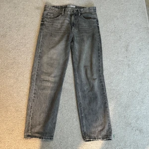 Grå raka jeans - Säljer ett par grå jeans med rak passform Jeansen har normal midja och är tillverkade i denim. 
