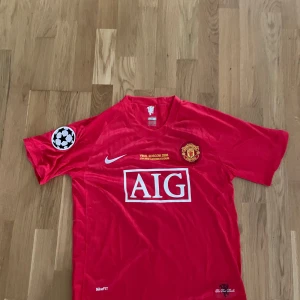 Manchester United fotbollströja signerad av Ronaldo - Säljer en röd Manchester United fotbollströja med AIG sponsortryck signerad av Ronaldo , Champions League-märke på ärmen och Ronaldo 7 på ryggen. Tröjan har korta ärmar och är från finalen i Moskva 2008. Perfekt för samlare eller fans! Pris kan diskuteras 