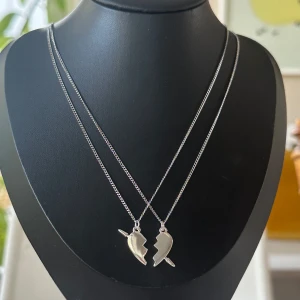 Maria Nilsdotter you and me inspererat halsband - Inspererat Halsband av Maria Nilsdotter. Två matchande silverhalsband med delade hjärthängen. Perfekt för att dela med en vän eller partner. Halsbanden är 100% rost och nickelfria och kedjorna är 40cm men går att förlänga med ytterligare 5cm. Vid mer frågor är det bara att höra av sig ☺️
