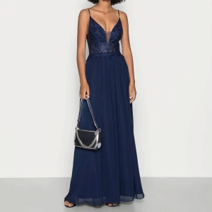 Marinblå lång balklänning  - Elegant marinblå klänning med djup v-ringning och tunna axelband. Endast använd 1 gång 