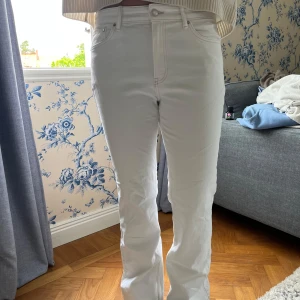 Vita bootcut jeans med hög midja - Snygga vita jeans med bootcut-modell och hög midja. Klassisk femficksdesign och raka ben som släpper ut nedtill. Perfekta för dig som vill ha en fräsch och stilren look. Materialet är mjukt och skönt bomullstyg.