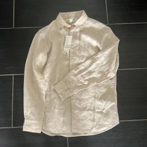 Uniqlo linne skjorta - Helt ny beige linne skjorta från uniqlo! Hör av dig om du har minsta fråga!☺️