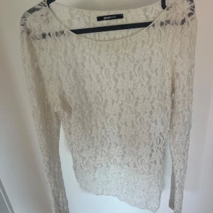 Vit spetsblus från Gina Tricot - Säljer en vit långärmad blus i spets från Gina Tricot. Blusen har en rund halsringning och är helt täckt av ett vackert spetsmönster. Perfekt att styla med jeans eller kjol för en trendig look. Storlek M men sitter bra på mig som är en S vanligtvis🤍