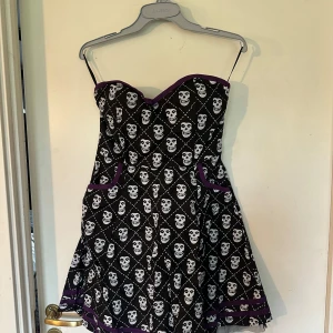Klänning fr Sourpuss Misfits M Axel lös modell - Helt ny klänning fr Sourpuss Missfits. Storlek M. Resårsmock i ryggen för att anpassa efter kroppen. Fickor. Skenor fram. Axel lös modell. Material i bomull.