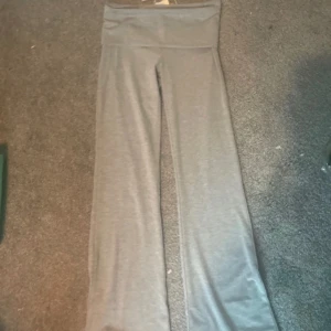 Grå yoga leggings från Gina Tricot - Snygga gråmelerade yoga leggings från Gina Tricot med hög midja och en stjärndetalj på ena benet. Mjukt och stretchigt material som passar perfekt för träning eller chill. Modellen är tight och har en enkel, stilren look.