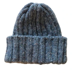 Blå ribbstickad mössa - Snygg blå ribbstickad mössa med bred uppvikt kant. Perfekt för kalla dagar och ger en chill vibe till din outfit. Tillverkad i mjukt stickat material som håller dig varm hela vintern.