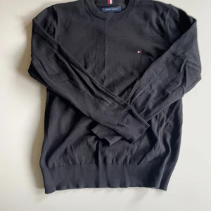 Svart långärmad tröja Tommy Hilfiger - Svart långärmad tröja från Tommy Hilfiger säljer för 200kr. Cotton cachemire men tvättad så har inte den mjuka texturen längre
