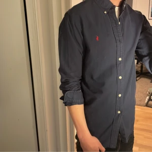 Ralph Lauren Skjorta - Tja säljer en Ralph lauren skjorta i färgen marinblå och i storlek M. Nypris 1595 KR mitt pris 299 KR. Inga defekter som hål eller fläckar. Skriv vid frågor eller funderingar.