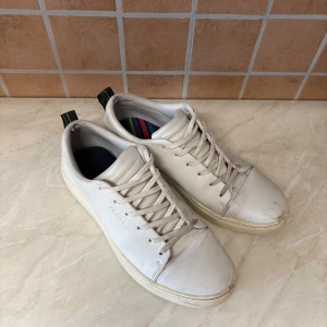 Sneakers Paul Smith - Säljer ett par vita paul smith sneakers i storlek 42. Dom är i bra skick men några märken men mycket liv kvar. 