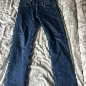 Levi's 511 blå jeansbyxor W30 L30 - Säljer ett par klassiska blå Levi's 511 jeans med normal passform och raka ben. Jeansen har fem fickor, dragkedja och knapp i midjan. Tveka inte på att fråga🤩