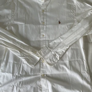  Ralph Lauren - Här har vi en tvär fet vit skjorta från raffe!      Knappt använd och är i riktigt bra skick.          Storleken är M=43cm.                                    Passar perfekt för dig som vill va tvär snygg i sommar!