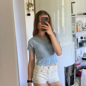 Ljusblå croppad t-shirt  -  ljusblå croppad t-shirt från newyorker med ”klipp” och korta ärmar. Perfekt till sommaren och enkel att matcha med både jeans och shorts. Snygg och stilren modell :))